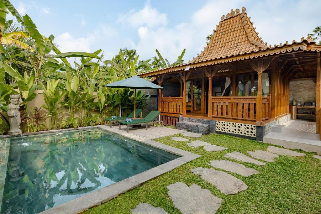 a villa with a swimming pool and a house at Suraya Ubud Villa in Ubud