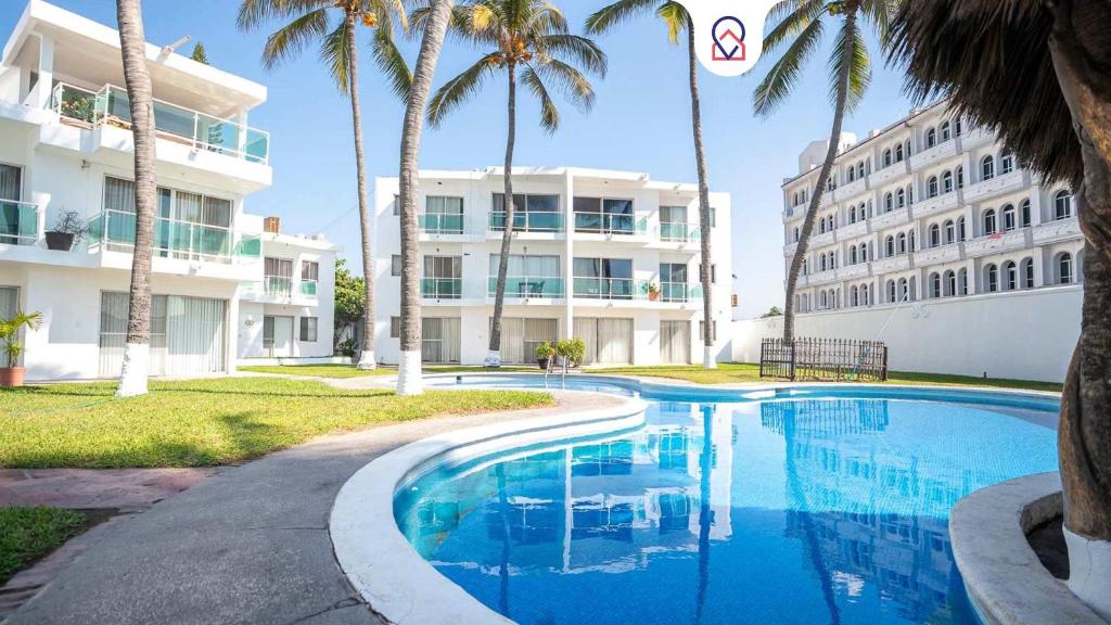 a swimming pool in front of a building at Playa Azul Apt with Sea views & Pool in Manzanillo