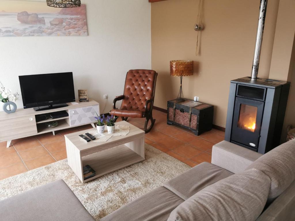 a living room with a couch and a wood stove at House in the montain Casa do Cabeço in Machico