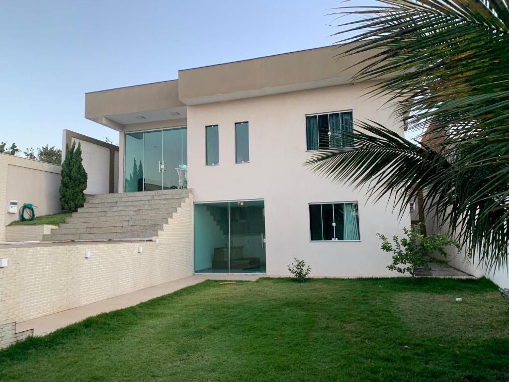 una casa bianca con una palma di fronte di Casa na praia de Ubu - Anchieta a Anchieta