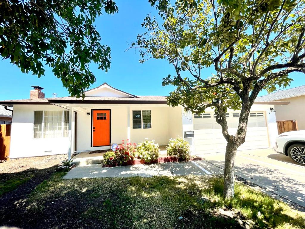 een huis met een oranje deur en een boom bij Cozy Home in the Valley 3 in San Jose