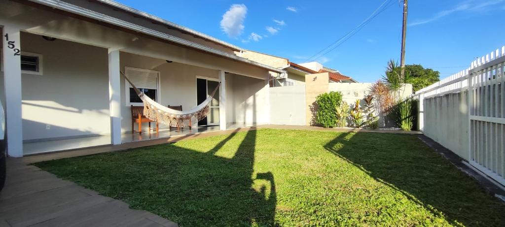 ein Hinterhof eines Hauses mit einem Rasen in der Unterkunft Praia do Sonho in Palhoça