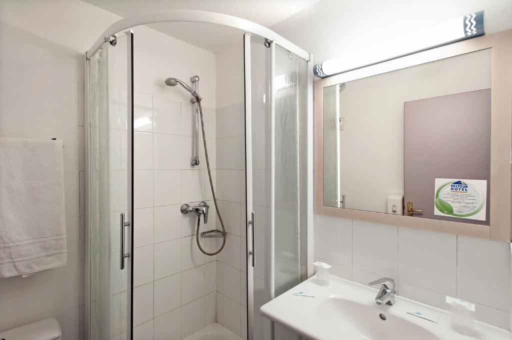 a bathroom with a shower and a sink and a mirror at BRIT HOTEL Essentiel CAHORS Nord in Cahors