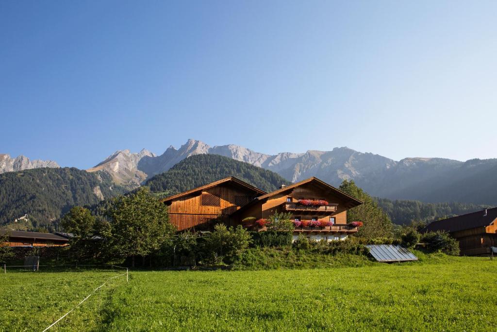 a house in a field with mountains in the background at Klampererhof in Virgen