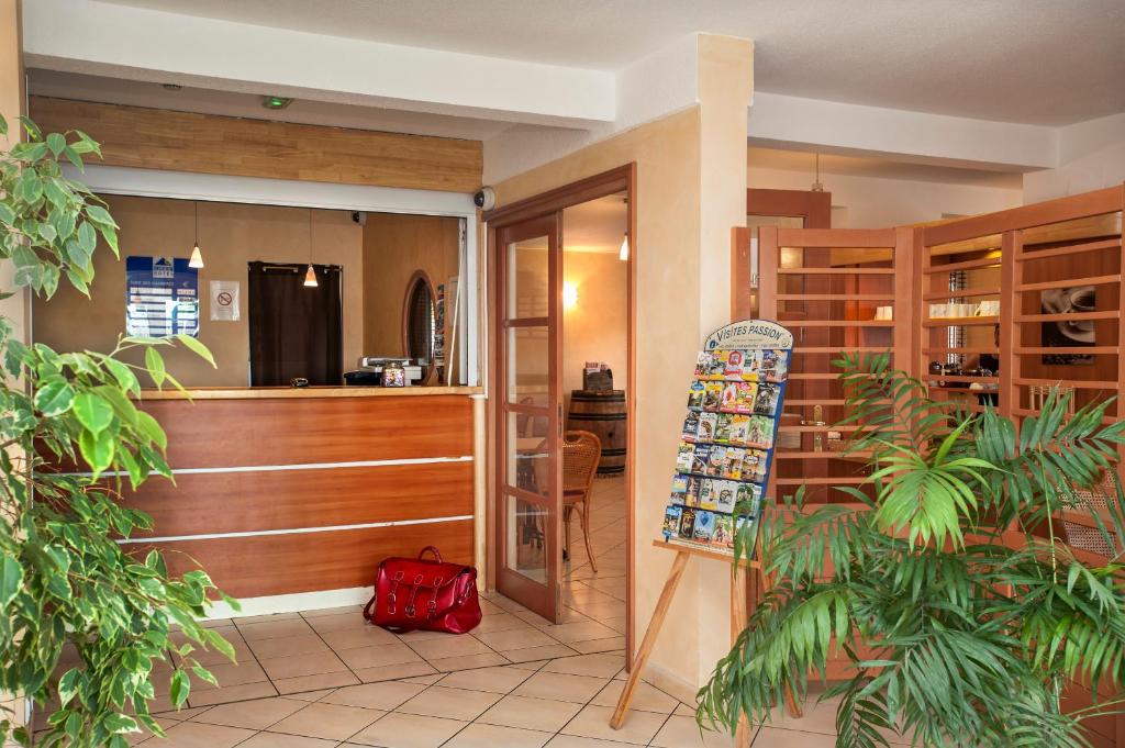 a lobby with a store with a red bag on the floor at BRIT HOTEL Essentiel CAHORS Nord in Cahors