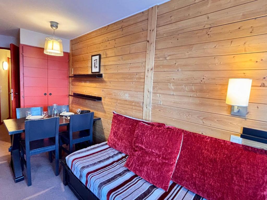 a room with a wooden wall with a couch and a table at Appartement 4 pers, balcon sud-est, quartier Falaise - FR-1-634-109 in Morzine