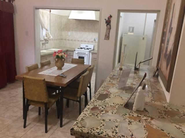 a kitchen with a table with chairs and a dining room at Alojartur in San Rafael