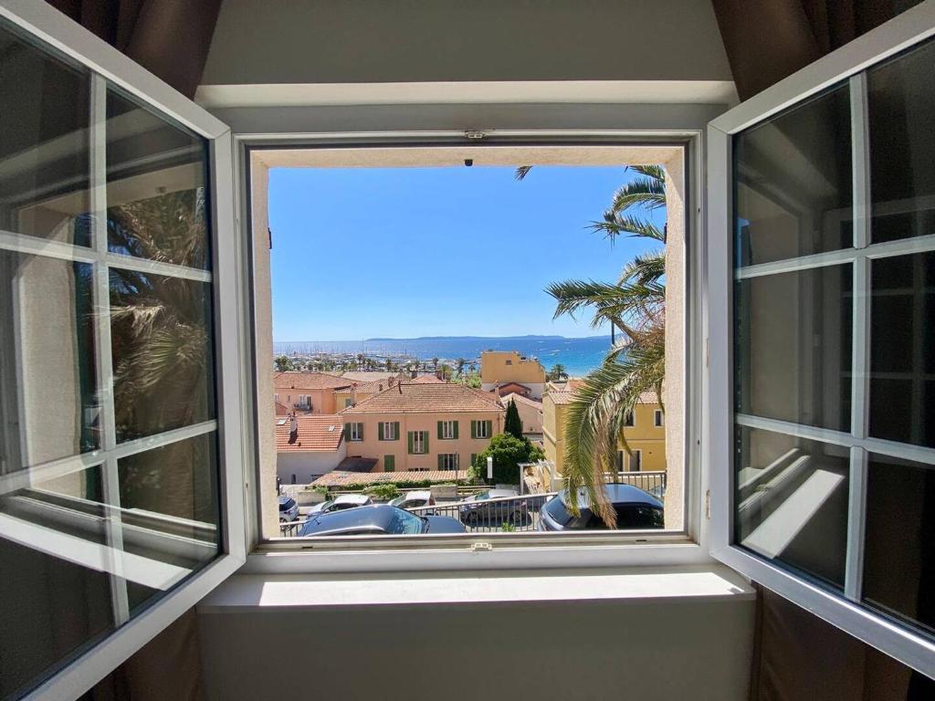 une fenêtre ouverte avec vue sur la ville dans l'établissement Appartement Central Climatisé au Lavandou - Proche Plage - FR-1-816-6, au Lavandou