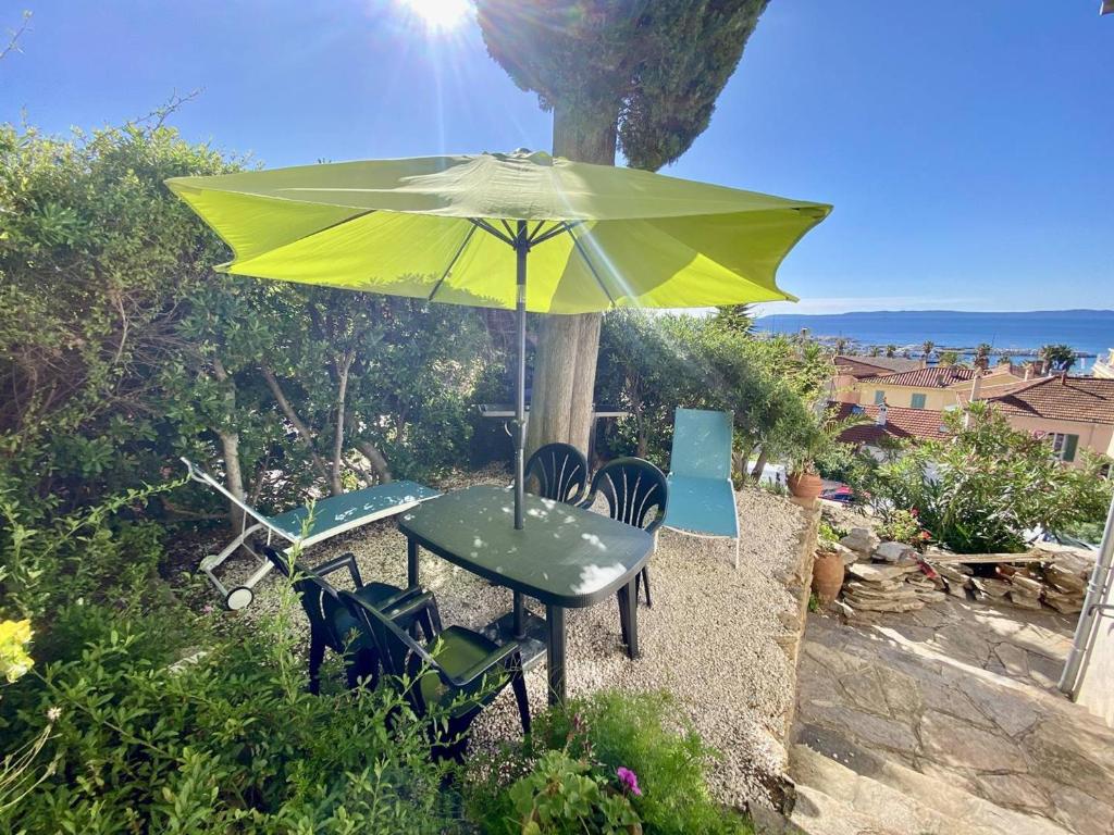 une table et des chaises sous un parapluie jaune dans l'établissement T2 Mezzanine au Lavandou, proche plage, climatisé - FR-1-816-8, au Lavandou