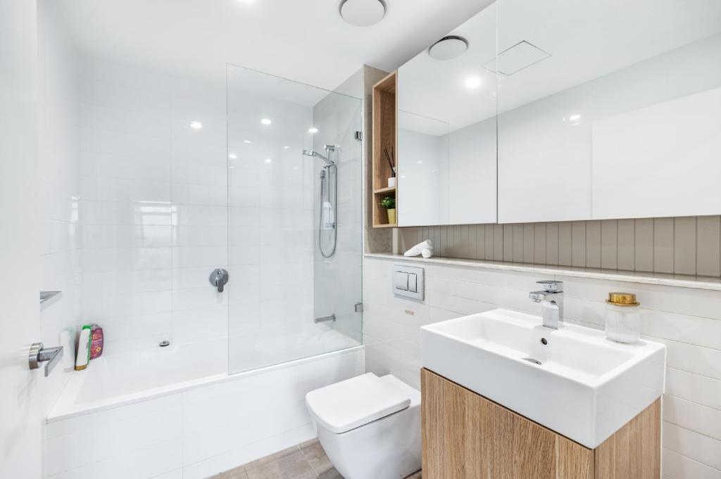 ein Badezimmer mit Waschbecken, Toilette und Dusche in der Unterkunft Your Luxury Weekend Getaway in Wentworth Point in Sydney