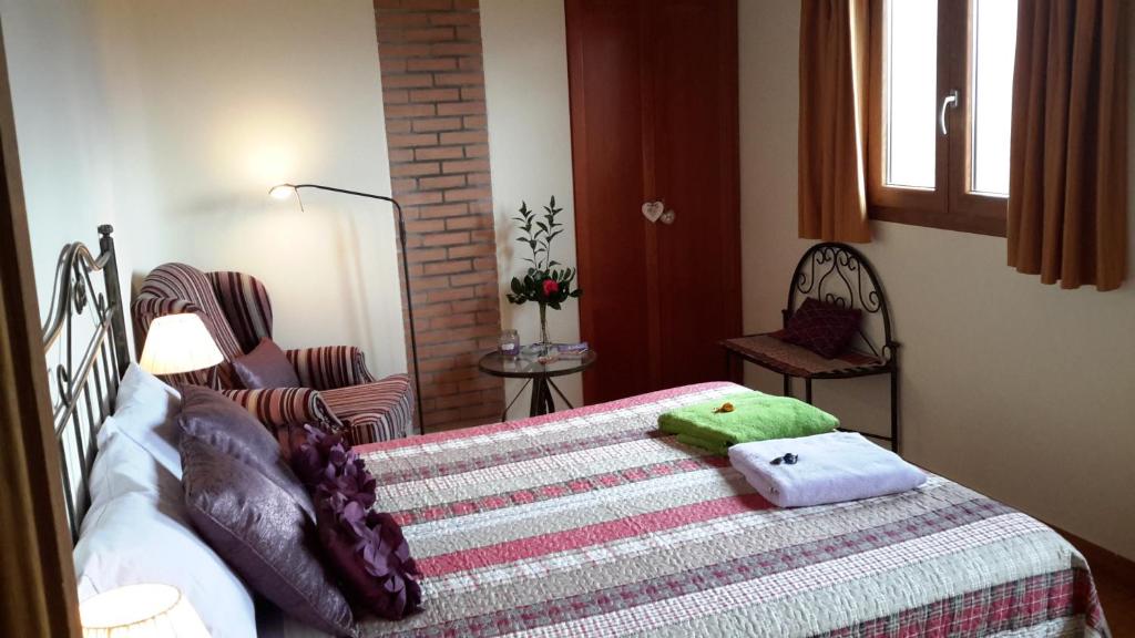 a bedroom with a bed with a green towel on it at La Trucha del Arco Iris in El Acebo de San Miguel