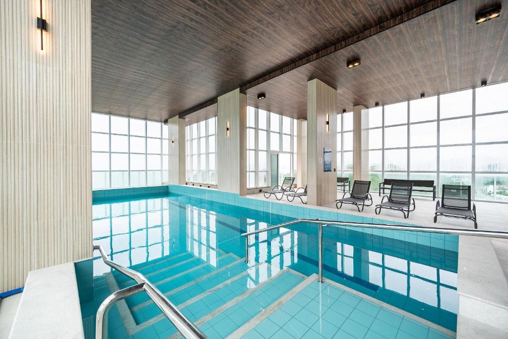 a large swimming pool with chairs and tables at Riviera Concept 2 dorm by Achei Camboriú in Itajaí