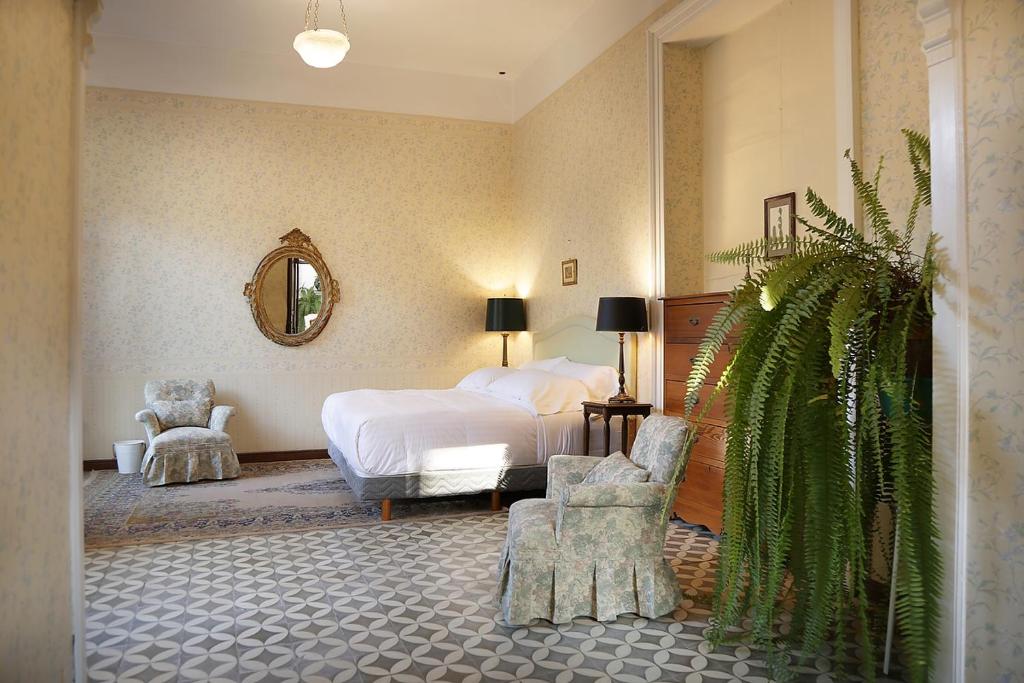 a bedroom with a bed and a chair and a plant at Casa Falguera en el Centro de Guanajuato 10p in Guanajuato