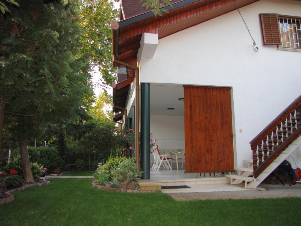 a house with a wooden door and a patio at Schmidt apartment in Balatonfenyves