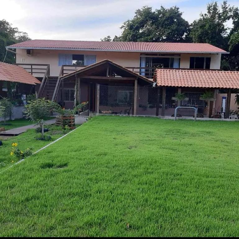 ein Haus mit einer großen Wiese davor in der Unterkunft vivencias in Itaquatiara
