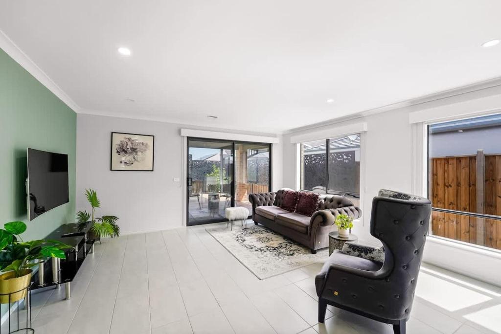 a living room with a couch and a tv at Ramlegh Spring Estate - High Quality Family Living in Clyde North