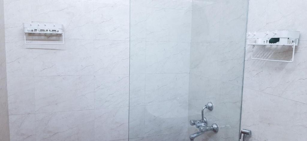a shower in a bathroom with a glass door at HappyHuts at Green valley view in Kodaikānāl