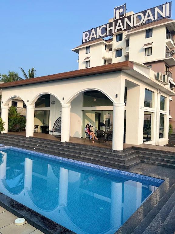 a hotel with a swimming pool in front of a building at Goa Riviera in Goa
