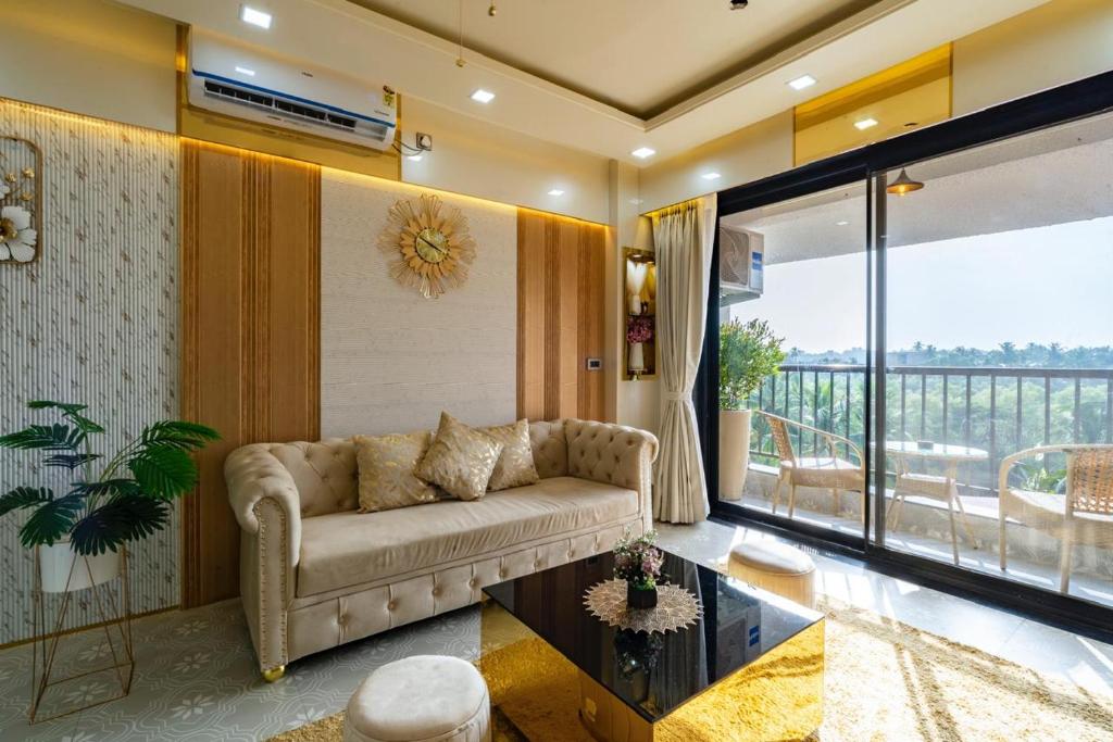 a living room with a couch and a large window at Goa Riviera in Goa