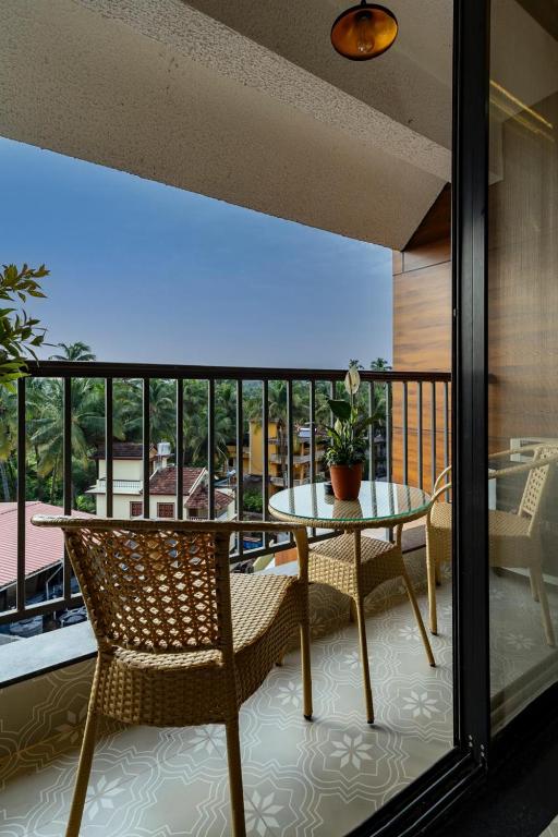 a balcony with a table and chairs and a view at Goa Riviera in Goa