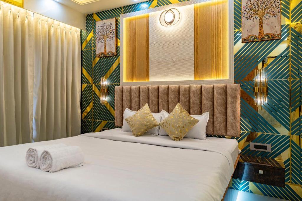 a bedroom with a bed and a wall with at Goa Riviera in Goa