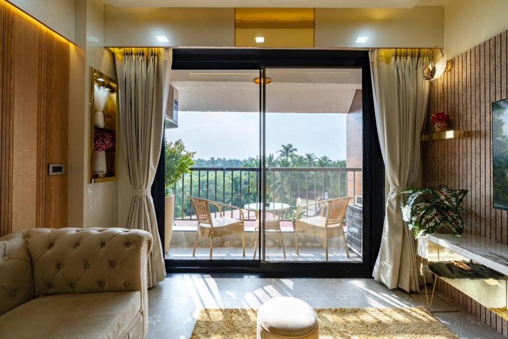 a living room with a couch and a sliding glass door at Goa Riviera in Goa