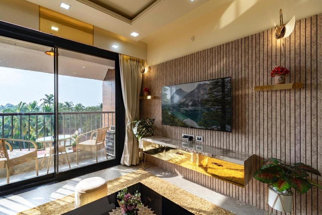 a living room with a television on a wall at Goa Riviera in Goa