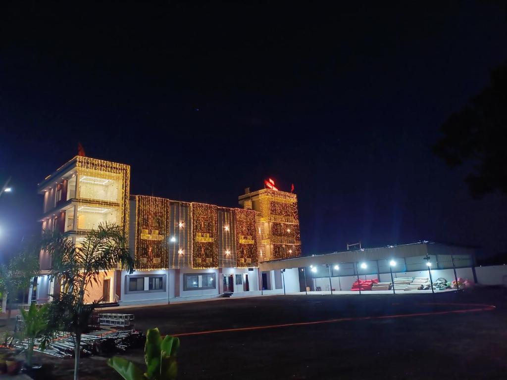 a large building with lights in front of it at night at Hotel Panna Shree in Ujjain