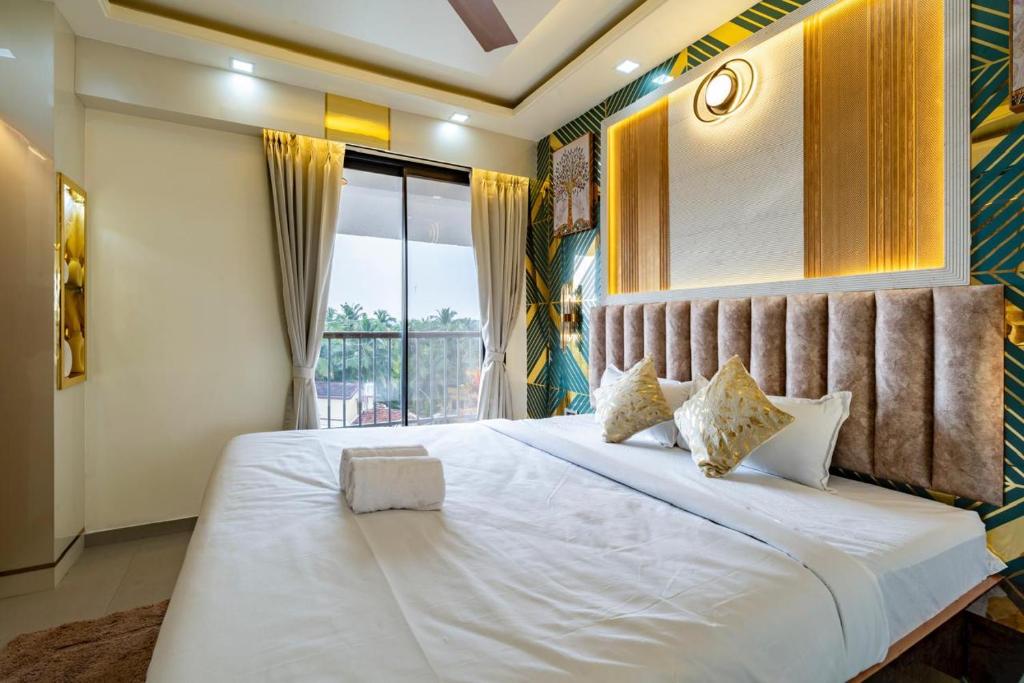a bedroom with a large white bed and a window at Goa Riviera in Goa