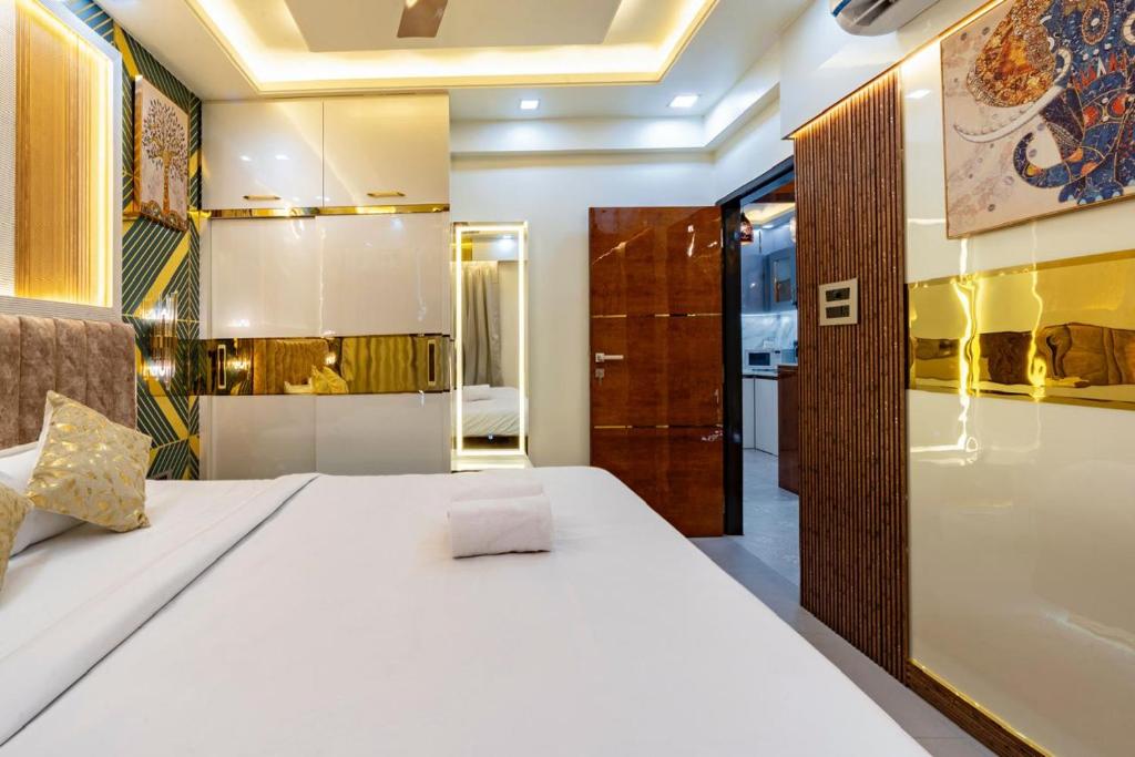 a bedroom with a white bed and a bathroom at Goa Riviera in Goa