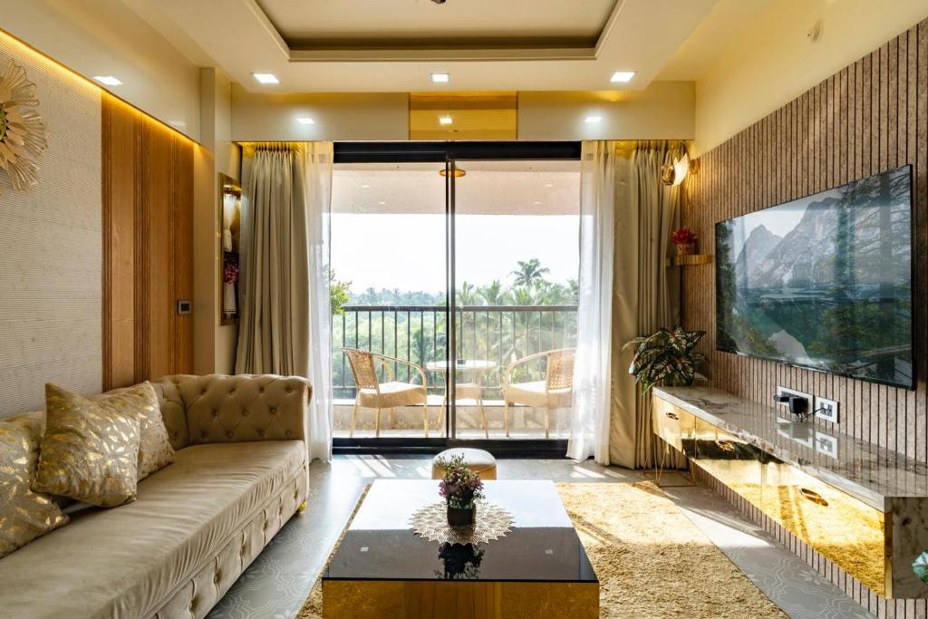 a living room with a couch and a tv at Goa Riviera in Goa