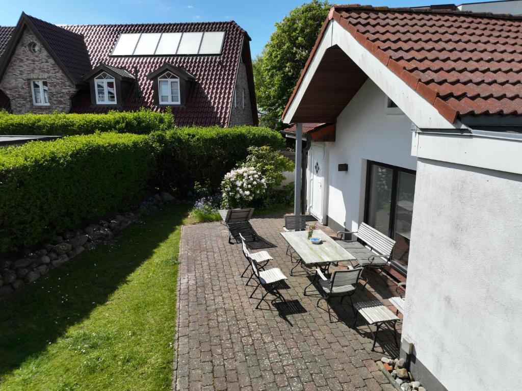 un patio con sillas y una mesa junto a un edificio en Kampstraße 1, Bungalow, en Westerland