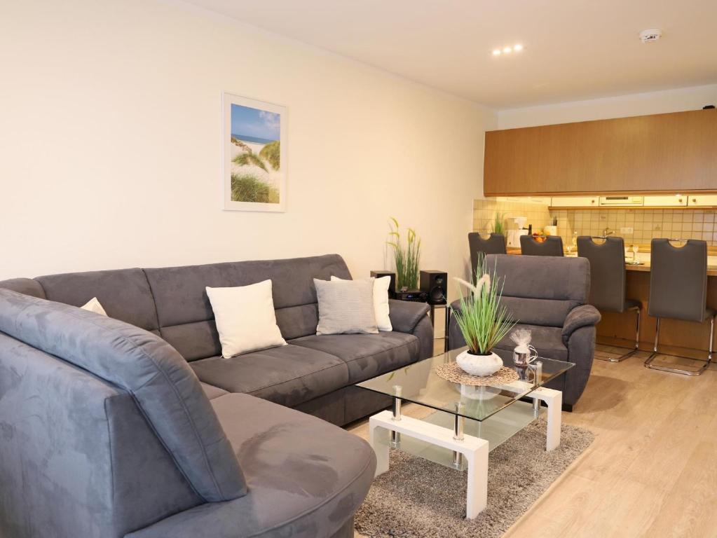 a living room with a couch and a table at Das geräumige 2-Zimmer-Appartement in Westerland (Sylt)