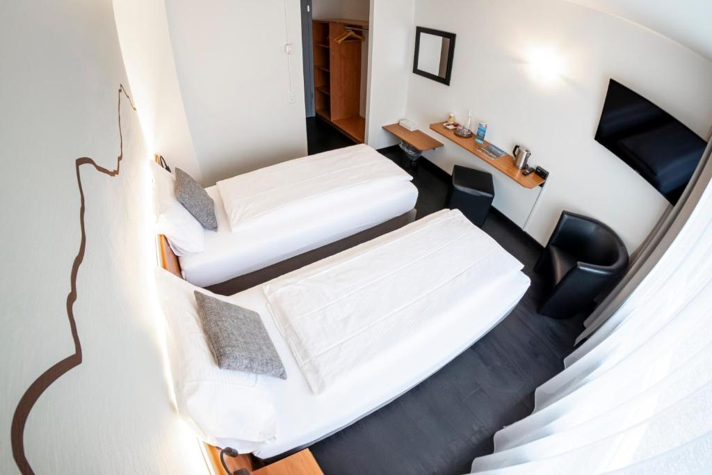 Postel nebo postele na pokoji v ubytování Hotel Merkur - West Station