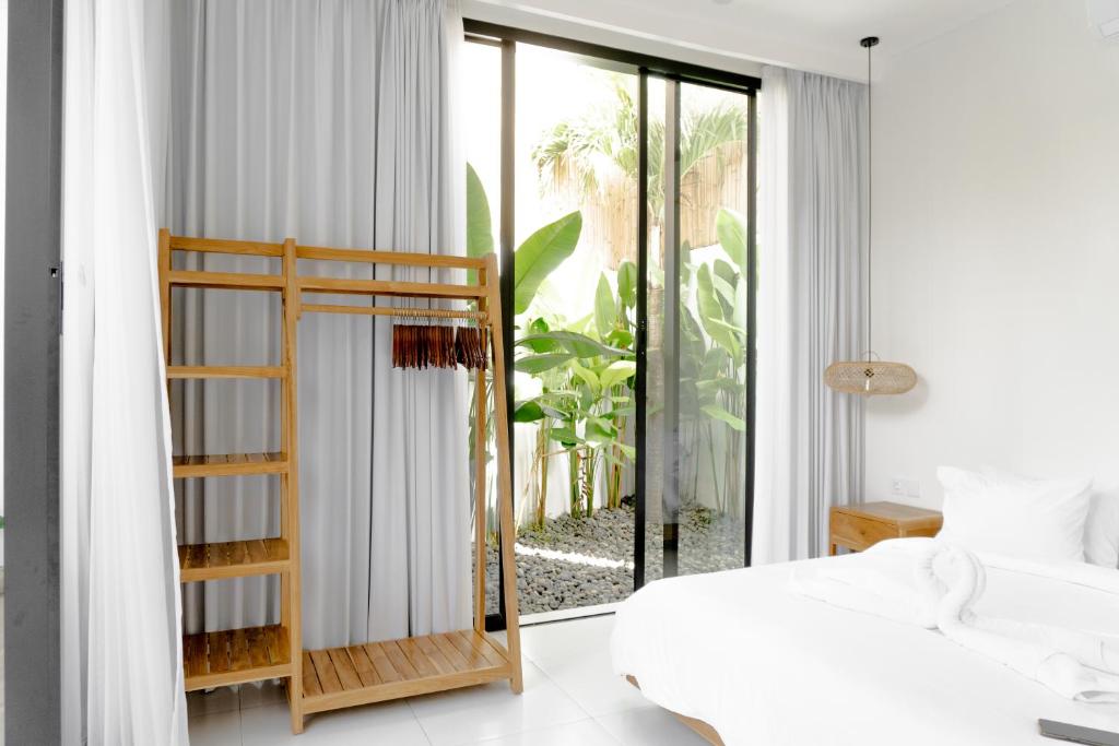 ein Schlafzimmer mit einem Bett und einem großen Fenster in der Unterkunft Casa Luna Villa in Kerobokan