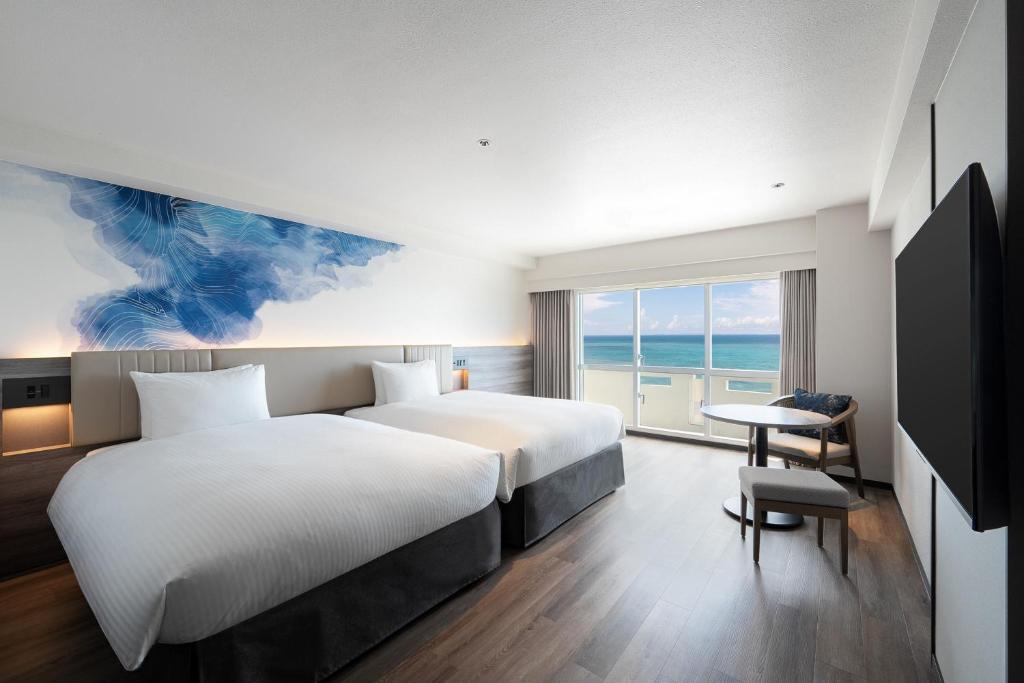 a hotel room with a bed and a desk and a window at Grand Mercure Okinawa Cape Zanpa Resort in Yomitan