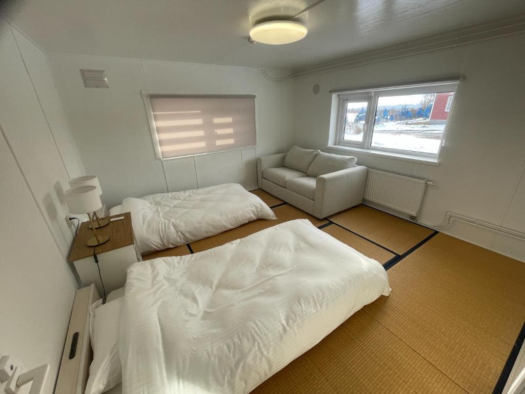 a room with two beds and a couch and a window at Rusutsu Golf&Ski Lodge - Vacation STAY 18169 in Rusutsu