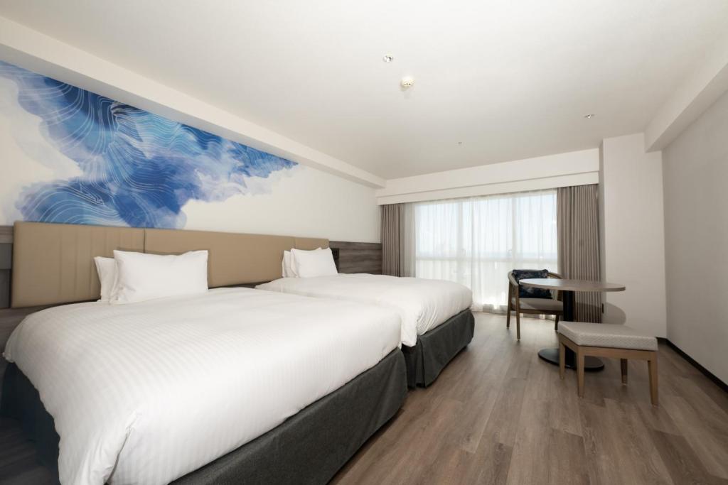 a hotel room with two beds and a desk at Grand Mercure Okinawa Cape Zanpa Resort in Yomitan