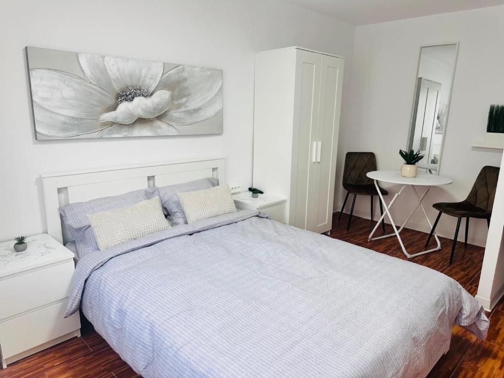 a bedroom with a bed with a flower painting on the wall at One Room Apartment Ptm 3 in Bucharest
