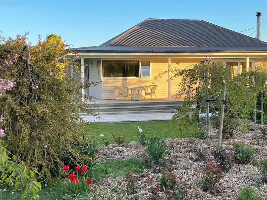 a yellow house with a garden in front of it at Waipara Valley Escape in Glasnevin