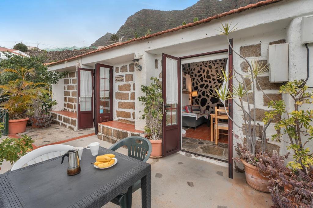 a patio with a table and chairs in front of a house at Casa Rural La Cuadra in Hermigua