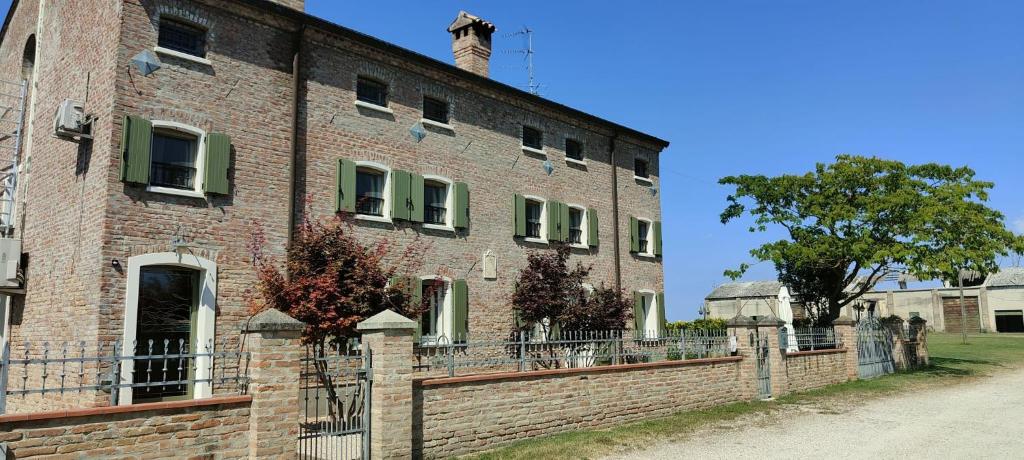 an old brick building with a fence in front of it at Casa Jolanda in Iolanda di Savoia
