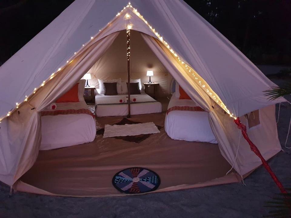 a tent with two beds in it with lights at Puerto Silanguin Beach Resort in Subic