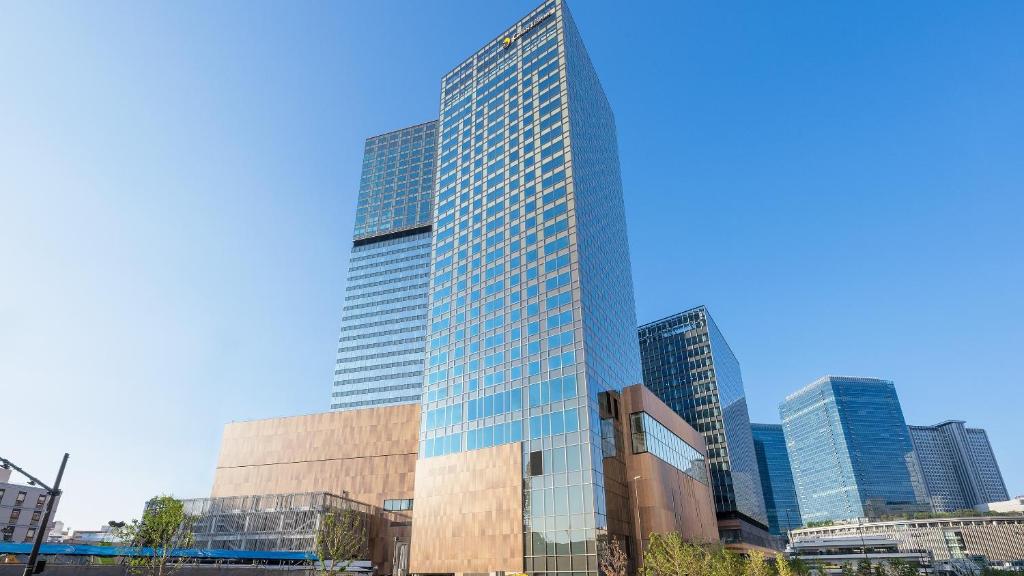 a tall building with many windows in a city at Hotel Hankyu GRAN RESPIRE OSAKA in Osaka
