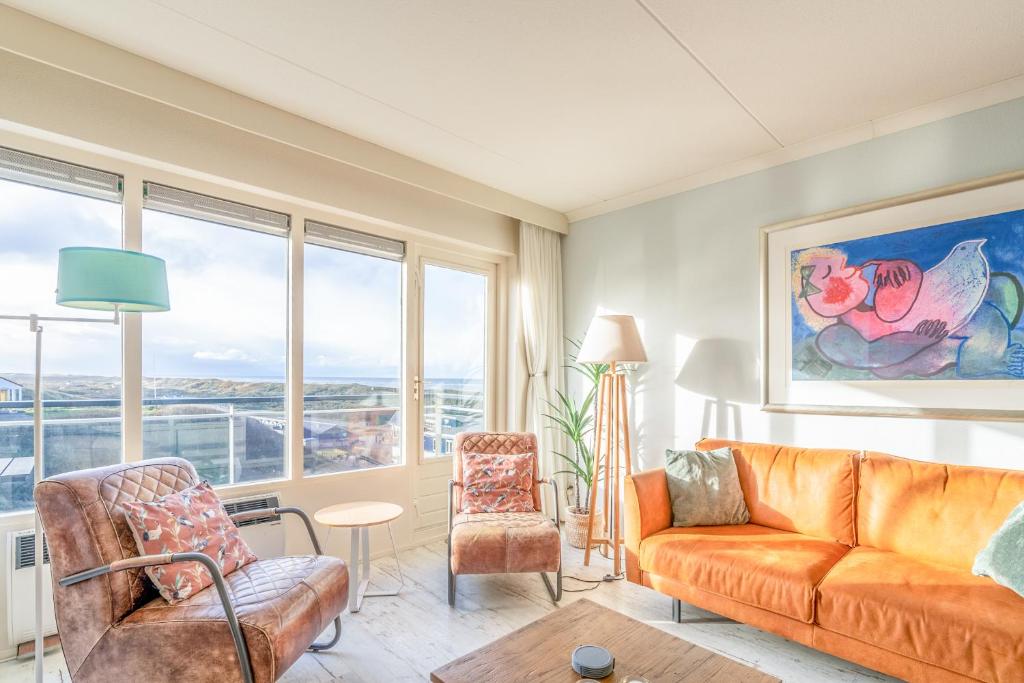 a living room with an orange couch and chairs at Appartementencomplex Juliana 148 in De Koog