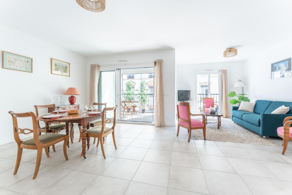 un salon avec une table et des chaises et un canapé bleu dans l'établissement MDOR - Octo Gone, à Lyon