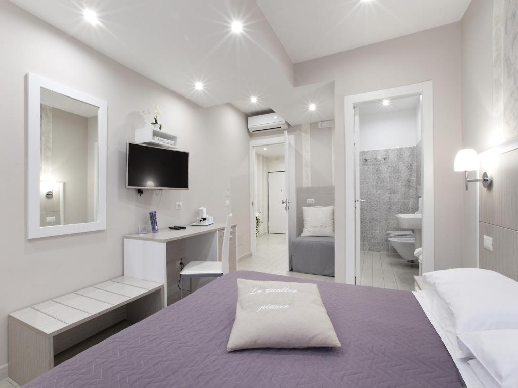 - une chambre blanche avec un lit et une salle de bains dans l'établissement Le Quattro Piazze, à Sorrente