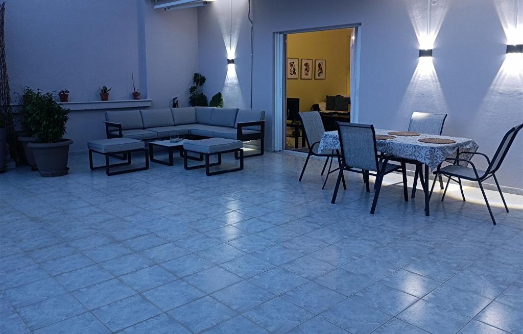 a living room with a couch and a table and chairs at Kelly's penthouse in Nafpaktos