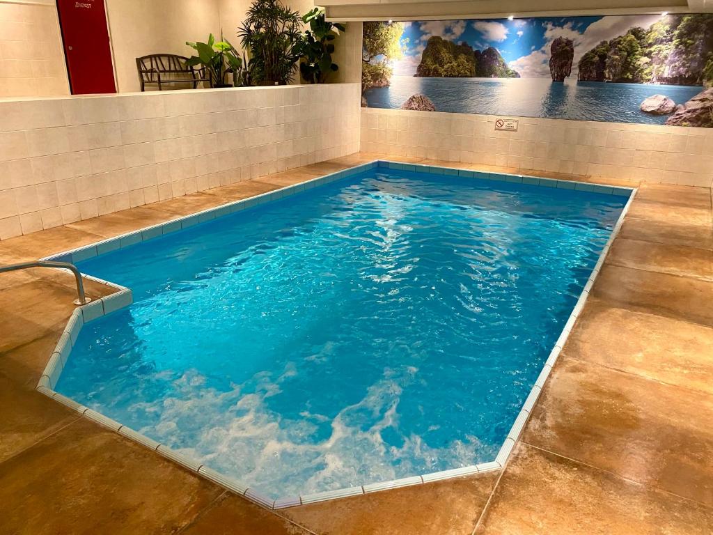 een groot zwembad met blauw water in een kamer bij Two Brothers Noordwijk Beach in Noordwijk aan Zee