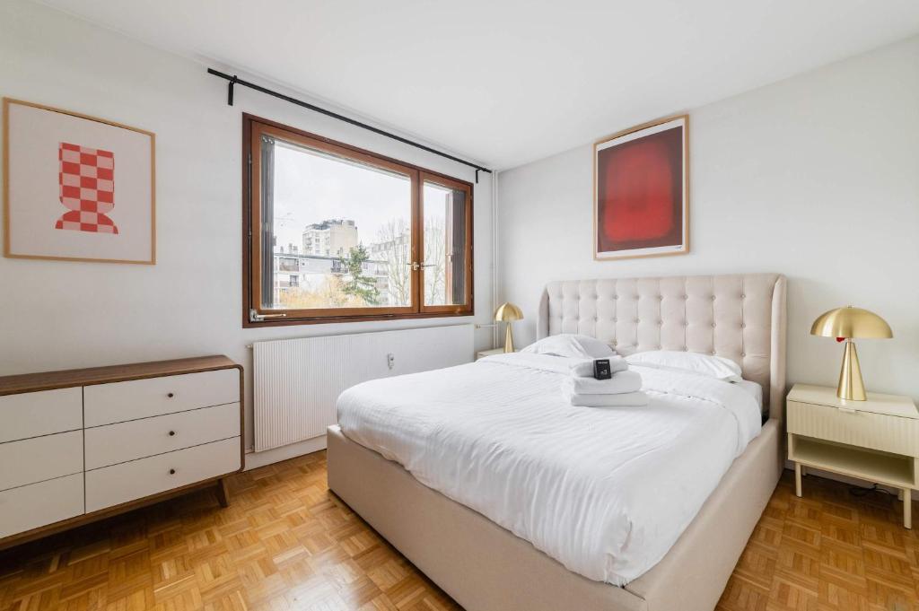 une chambre blanche avec un grand lit et une fenêtre dans l'établissement Appartement Paisible proche parc des princes - 4P - FLAT-GUEST, à Boulogne-Billancourt